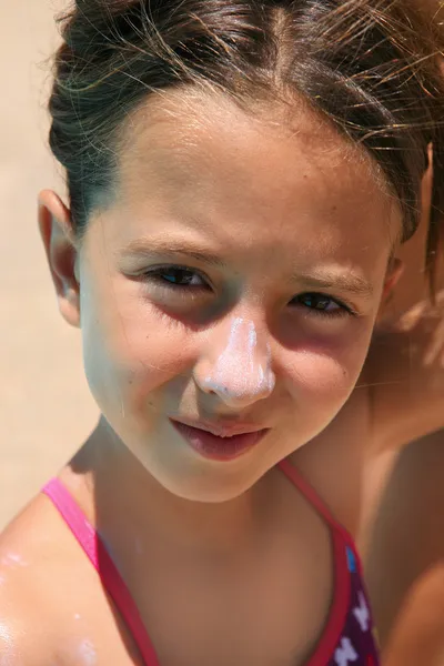 Meisje met zonnebrandcrème in haar nouse — Stockfoto