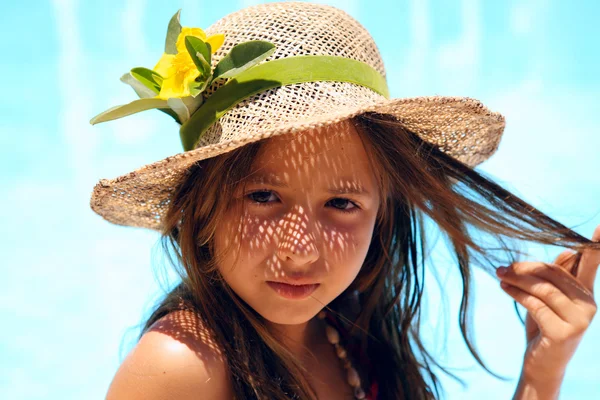 Klein meisje dragen van een hoed in de buurt van zwembad — Stockfoto