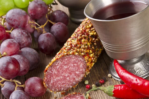 Vin och salami på en trä bakgrund — Stockfoto