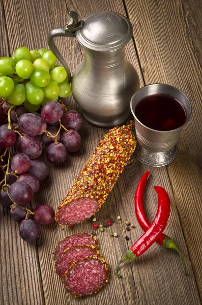 Wino i salami na drewnianym tle — Zdjęcie stockowe