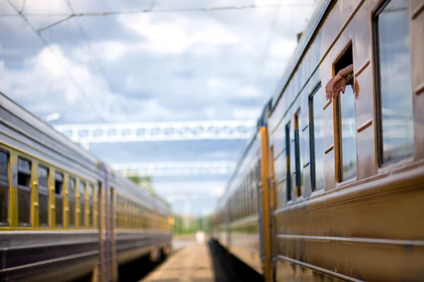 Руки вылетающих пассажиров в окне поезда — стоковое фото