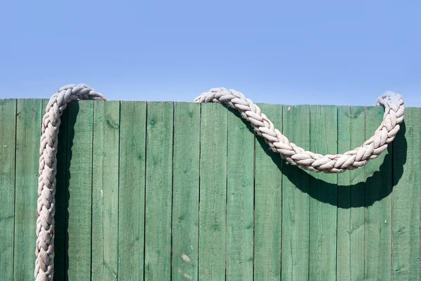 Amarrar corda em uma cerca verde — Fotografia de Stock