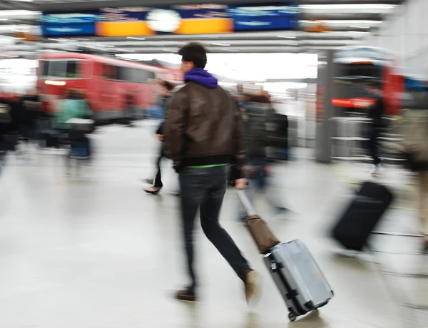 Homem de passageiros caminhando com um saco na estação raolway perto do trem — Fotografia de Stock