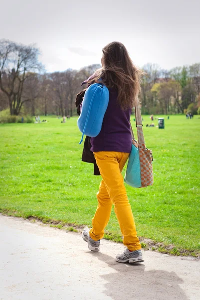 Young woman walking on path in city park — Stock Photo, Image