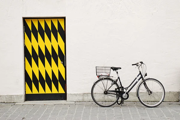 Gamla staden cykel againtst en stor vägg med dörr — Stockfoto