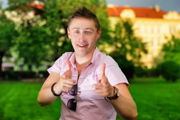 Молодий чоловік посміхається обличчям в парку — стокове фото