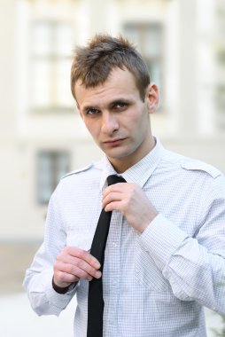 Close up portrait of businessman tying black tie clipart