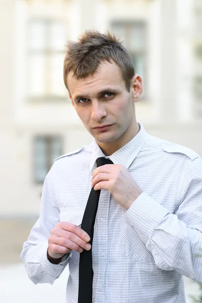 Gros plan portrait d'un homme d'affaires attachant une cravate noire — Photo