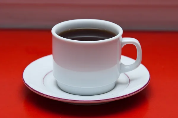 Kopp kaffe på röda bordet — Stockfoto