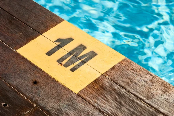 Designation of the swimming pool depth of 1 meter on a wooden floor — Stock Photo, Image
