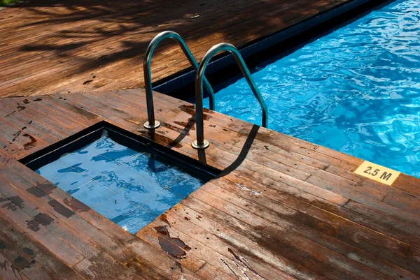 Бассейн с лестницей и деревянным полом — стоковое фото