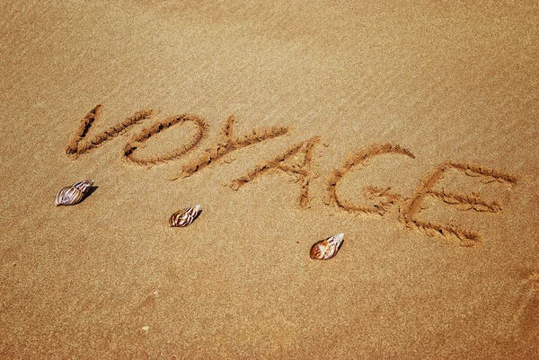 Inscription on wet sand voyage — Stock Photo, Image