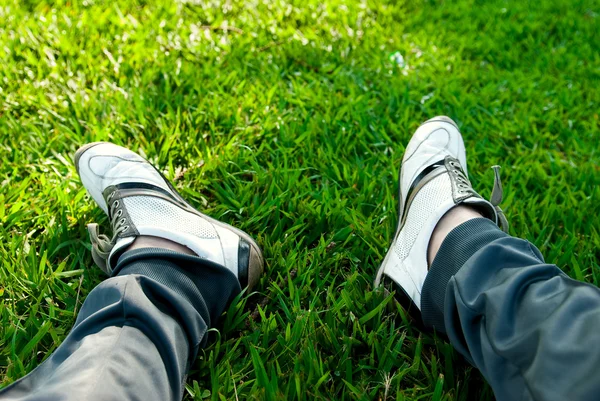 Concept photo de repos. Les pieds des hommes en baskets et pantalons de sport — Photo