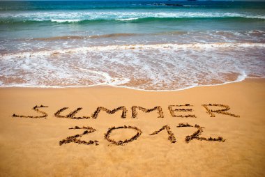 Inscription on wet sand Summer 2012 clipart