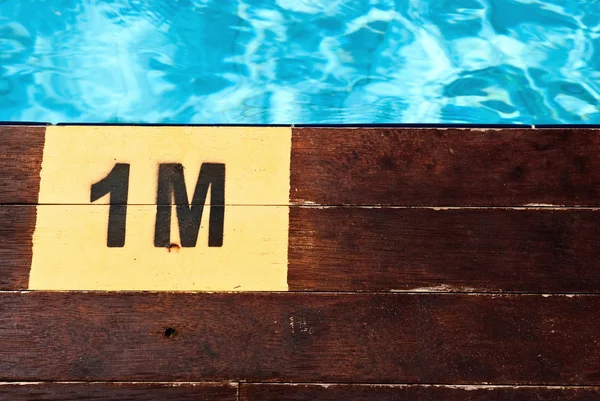 Inscription of the swimming pool depth of 1 meter on a wooden floor — Stock Photo, Image