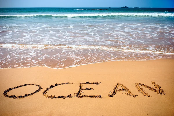 Ιδιόχειρη επιγραφή ωκεανό στην άμμο σε μια παραλία — Φωτογραφία Αρχείου