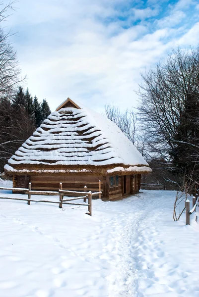 stock image Small wooden houses in winter against blue sky