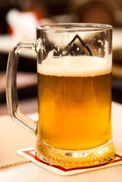 Kopp med øl som ligger tett inntil bordet på kafeen – stockfoto