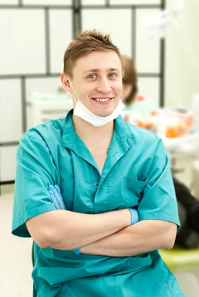 Portrait of a happy dental doctor smiling with dental office in the background — Stock Photo, Image