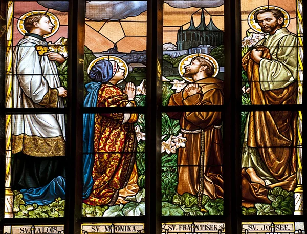 Blyinfattade fönster i gamla kyrkan med fyra heliga person be — Stockfoto