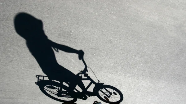 Sombra de criança em uma bicicleta — Fotografia de Stock