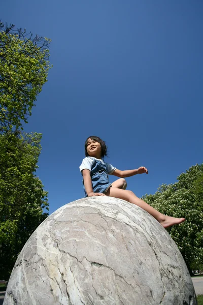 Ребенок на сферической скале — стоковое фото