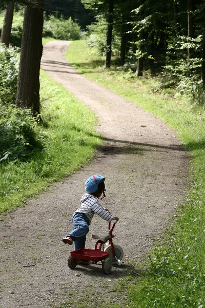 彼女のサイクルと遊ぶ子供 — ストック写真