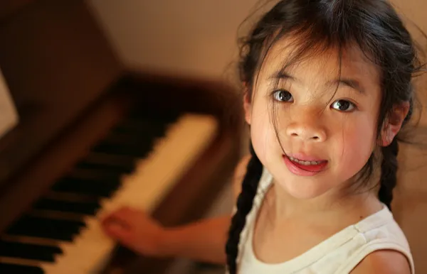 Profiel van het kind op piano — Stockfoto