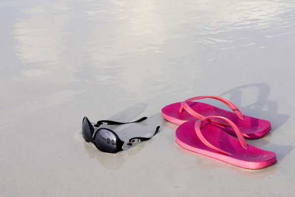 Klapki i okulary przeciwsłoneczne na plaży — Zdjęcie stockowe