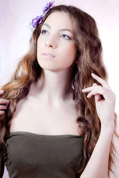 Mladá krásná žena s květinami ve vlasech — Stock fotografie