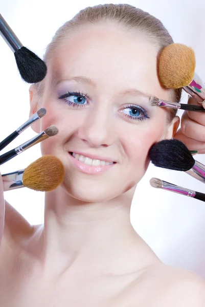Młoda kobieta z pędzlami do makijażu — Zdjęcie stockowe