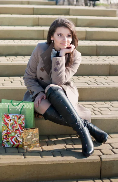 Menina bonita sentada com sacos de compras — Fotografia de Stock