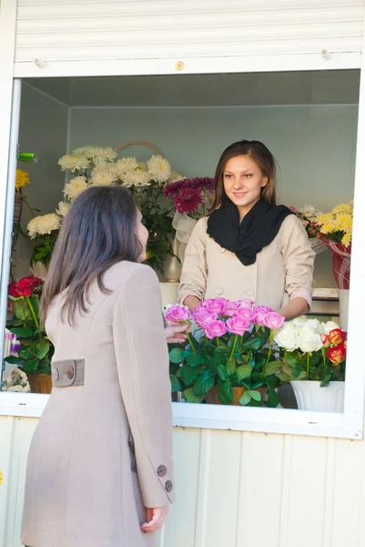 Vacker ung flicka köpa blommor — Stockfoto