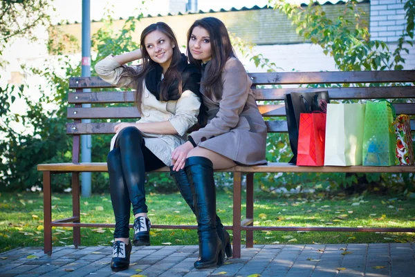 Duas meninas bonitas sentadas no banco — Fotografia de Stock