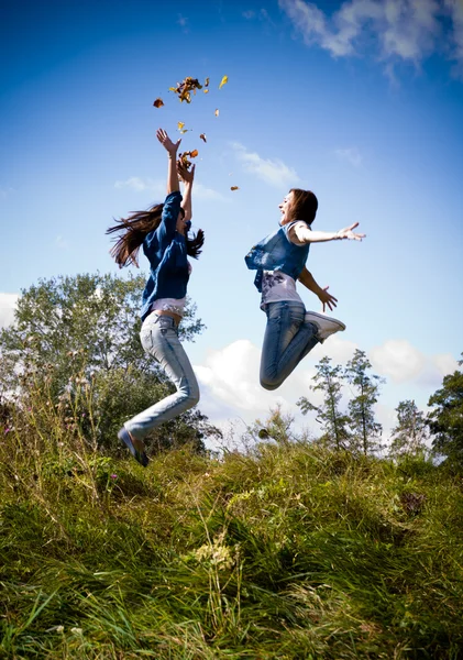 Duas meninas pulando alto animado — Fotografia de Stock