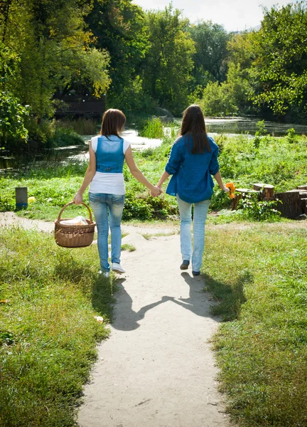 Dvě dívky procházky ruku v ruce — Stock fotografie