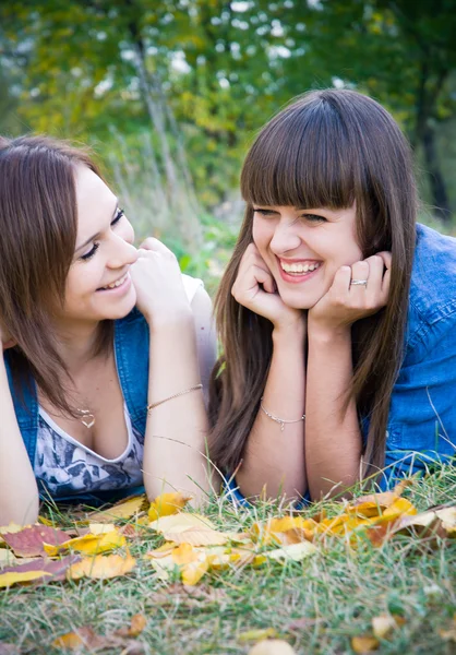 Duas meninas deitadas em folhas de outono — Fotografia de Stock