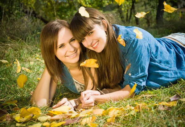 Дві дівчини лежать в осінньому листі — стокове фото