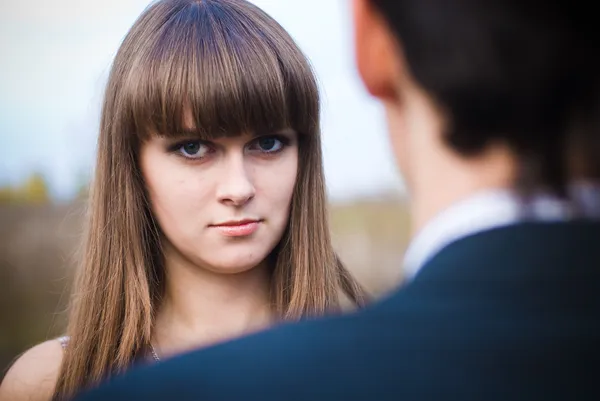 Woman looking seriously over man shoulder — Stock Photo, Image