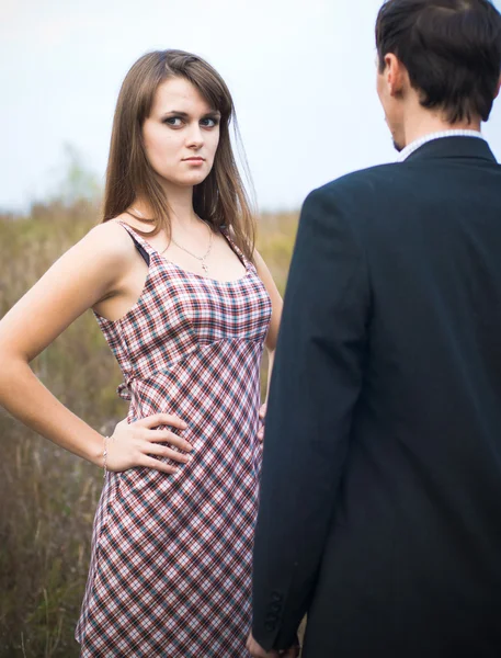 Vrouw op zoek beledigd over man schouder — Stockfoto