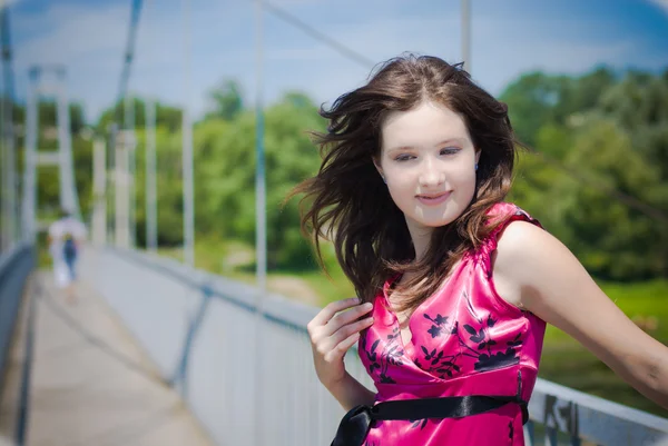 Köprü üzerinde parlak pembe elbiseli genç kız — Stok fotoğraf