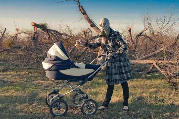 Mère en masque à gaz avec bébé buggy — Photo