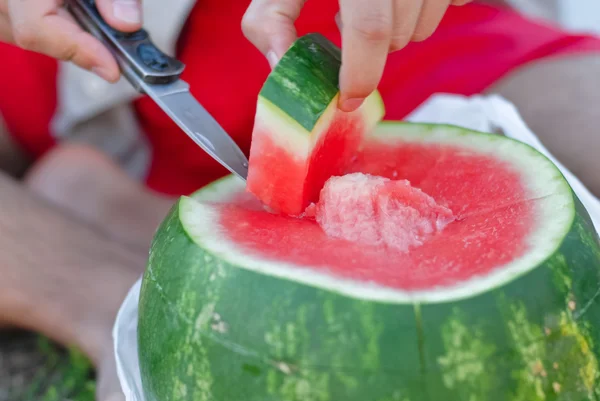 Cutting a piece of watermelon — Stock Photo, Image