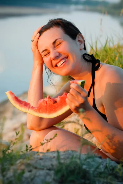 Young woman with a watermelon on river bank — Stock Photo, Image