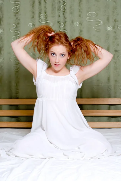 Jovem garota puxando o cabelo e olhando divertido — Fotografia de Stock