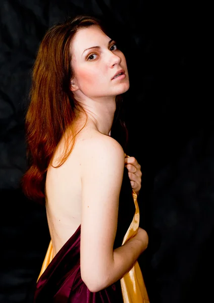 Mulher segurando tecidos de cetim com ombro nu — Fotografia de Stock