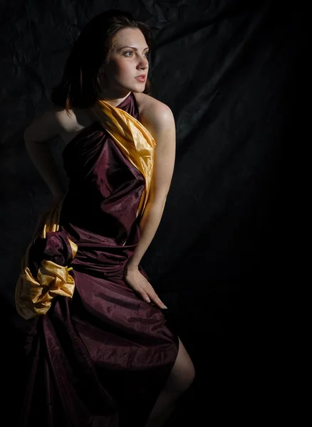 Siyah zemin üzerine kırmızı altın elbiseli kadın — Stok fotoğraf