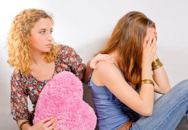 Young teenage girl comforting her friend clipart