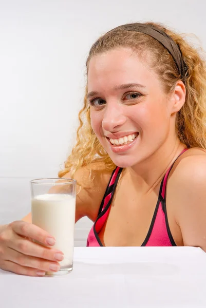 Mladá dívka se sklenicí mléka — Stock fotografie