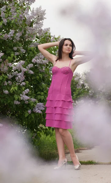 Jonge mooie vrouw ruiken roze Lila — Stockfoto
